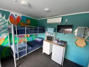 een kamer met een stapelbed, een bureau en een computer bij Hello! Accommodation in Tauranga