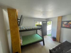 Zimmer mit 2 Etagenbetten und einem Sofa in der Unterkunft Hostería El Sendero - Cocorná in Cocorná