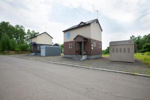 a house with a garage on the side of a street at Yotei Chalets in Niseko