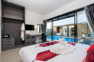a bedroom with a large bed and a swimming pool at Thames Tara Private Pool Villa Rawai Phuket - SHA Extra Plus in Rawai Beach