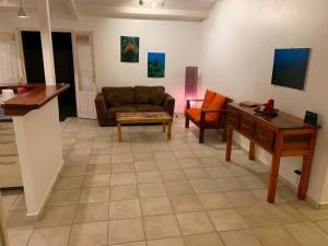 a living room with a couch and a table at Villa coco in Bouillante