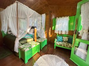 Zimmer mit 2 grünen Betten und einem Kinderbett in der Unterkunft Sequoia Casa na Árvore, Vila Mágica in Bueno Brandão