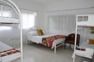 a bedroom with a bed and a chair and bunk beds at VILLA ALEJANDRIA - CABAÑA LAMARIQUITA-CABAÑA ORQUIDEA-CABAÑA CARAMBOLa in Mariquita