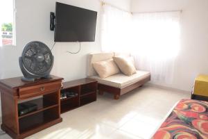 a living room with a couch and a fan at VILLA ALEJANDRIA - CABAÑA LAMARIQUITA-CABAÑA ORQUIDEA-CABAÑA CARAMBOLa in Mariquita