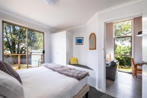 - une chambre avec un lit et une grande fenêtre dans l'établissement Wineglass, à Coles Bay