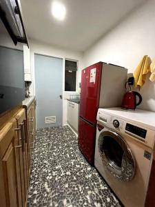 a kitchen with a red refrigerator and a washing machine at Casa Entre Glaciares in Puerto Natales