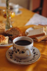 a cup of coffee sitting on a table with bread at Hotel Colonial Salta in Salta
