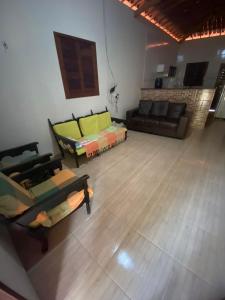 a living room with couches and a wooden floor at Chácara Tantan - Martins RN in Martins