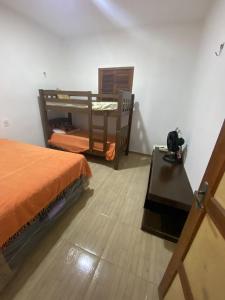 a bedroom with a bed and a desk and a table at Chácara Tantan - Martins RN in Martins