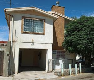 una casa con un garaje y un árbol en Departamento Valle Verde A 10 minutos consulado, en Ciudad Juárez
