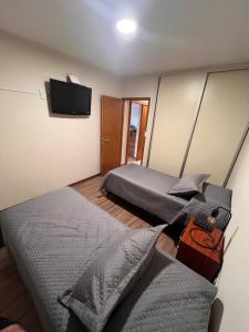 een slaapkamer met 2 bedden en een flatscreen-tv bij Luis Maria Depto1 in San Martín
