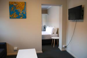 a room with a bed and a flat screen tv at Beltana Hotel in Lindisfarne