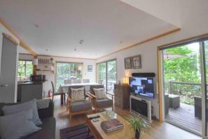 a living room with a couch and a table with a tv at Hakuba Colonsay- Amazing views 3bdr 2bth cottage in Hakuba