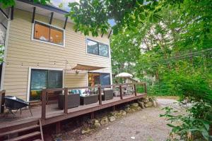 a house with a large deck in front of it at Hakuba Colonsay- Amazing views 3bdr 2bth cottage in Hakuba