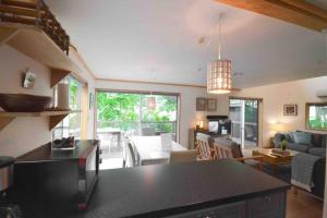 a kitchen and living room with a black counter top at Hakuba Colonsay- Amazing views 3bdr 2bth cottage in Hakuba