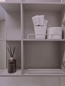 a white cabinet with white shelves with utensils at M studio Sondo Centralpark in Siheung