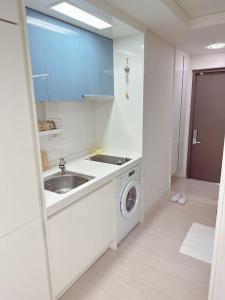 una cucina con lavandino e lavatrice di M studio Sondo Centralpark a Siheung