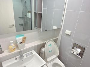 a bathroom with a toilet and a sink and a mirror at M studio Sondo Centralpark in Siheung