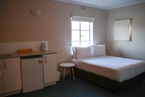 a small room with a bed and a small kitchen at Beltana Hotel in Lindisfarne