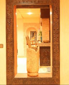 Una imagen de un espejo en una habitación con chimenea. en Hôtel LAKASBAH Ait Ben Haddou, en Aït Ben Haddou