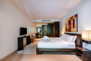 une chambre avec un grand lit et une télévision dans l'établissement Poppy Beachfront Residence, à Rawai Beach 92 autres photos
