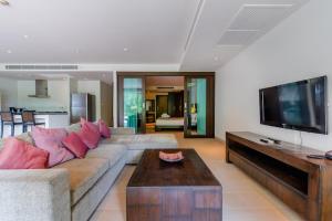 un salon avec un canapé et une télévision à écran plat dans l'établissement Poppy Beachfront Residence, à Rawai Beach