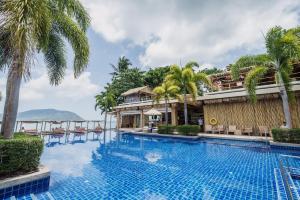 a pool at a resort with palm trees at Daisy 2 Bed Amazing Seaview in Rawai Beach