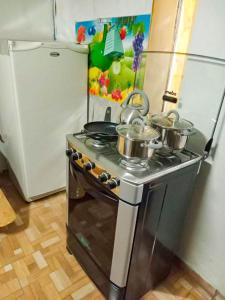 - une cuisine équipée d'une cuisinière avec des casseroles et des poêles dans l'établissement HABITACIONES ISABEL, à Lima