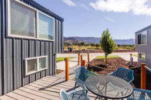 un patio con mesa y sillas en una terraza en New calm & relaxing Tiny House w deck near ZION, en Apple Valley