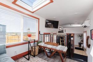 New calm & relaxing Tiny House w deck near ZION في Apple Valley: غرفة معيشة مع طاولة ونافذة