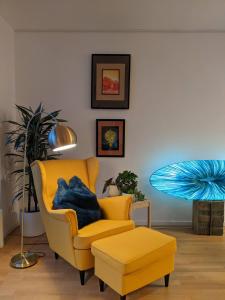 un salon avec une chaise jaune et une lampe dans l'établissement Luxury, Spacious, Sunny home in the heart of Berlin, à Berlin