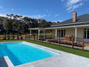 a swimming pool in front of a house at Yallingup Homestead Guest House in Dunsborough