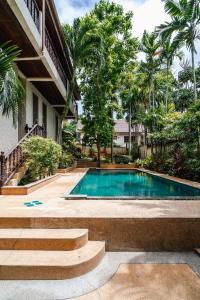 a swimming pool in front of a house with trees at Orchid Pool Villa in Rawai in Rawai Beach