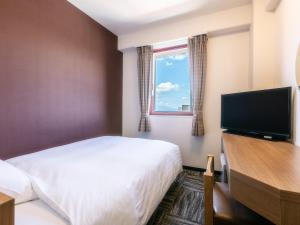 una camera d'albergo con un letto e una TV a schermo piatto di Hotel Wing International Sukagawa a Sukagawa