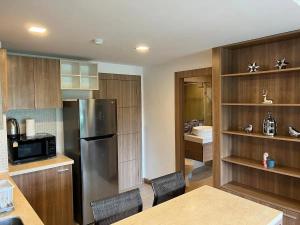 Una cocina con refrigerador de acero inoxidable y gabinetes de madera. en Calypso gardens in Nai Harn, en Rawai Beach