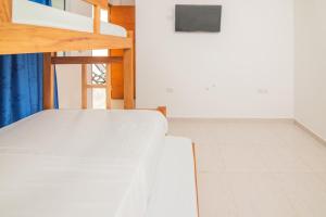uma cama branca num quarto com uma escada em Habitacion Playa Linda 103 em Coveñitas