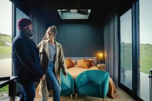 a man and woman standing in a bedroom with a bed at CABN Kangaroo Island in Penneshaw