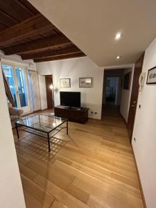ein Wohnzimmer mit einem Glastisch und einem TV in der Unterkunft Casa dei Mercanti in Verona