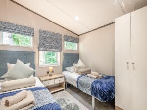 duas camas num pequeno quarto com duas janelas em Tranquil Dawn em Corton