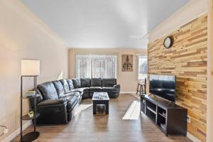 un soggiorno con divano in pelle e TV di Modern Cozy 1 Bedroom Apartment in Shelby Township a Shelby