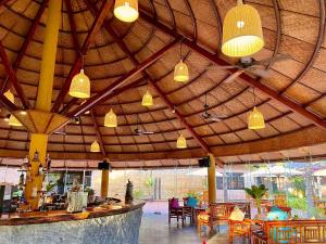 ein Restaurant mit einer großen Holzdecke mit Tischen und Stühlen in der Unterkunft ENSO Retreat Hoi An in Hoi An