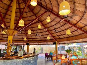a restaurant with a large wooden ceiling with tables and chairs at ENSO Retreat Hoi An in Hoi An