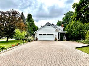 ein weißes Haus mit einer Garage und einer Auffahrt in der Unterkunft Settlers Suites in Niagara on the Lake