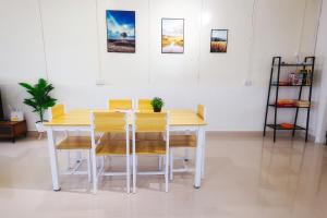 un tavolo giallo e sedie in una stanza di monstera guesthouse (Lenggong) a Kampong Ulu Jepai