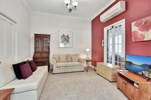 a living room with a couch and a tv at Tabitha Hill Cottage close to wineries and nature in Bellbird