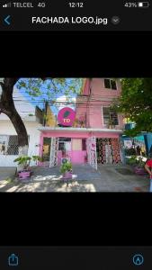 un edificio rosa con un cartel en el costado en Tropical Dreams en Villahermosa
