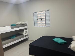 Una habitación blanca con una cama y una ventana. en Casa dos Devotos Aparecida 10 pessoas, en Aparecida
