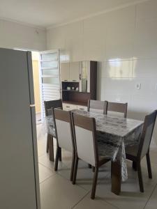 Un comedor con mesa y sillas y una cocina. en Casa dos Devotos Aparecida 10 pessoas, en Aparecida