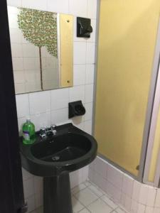 baño con lavabo negro y espejo en Apartamento enorme y acogedor en Ibagué, en Ibagué