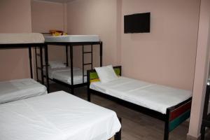 a room with three bunk beds and a flat screen tv at Hotel La Castella in San José